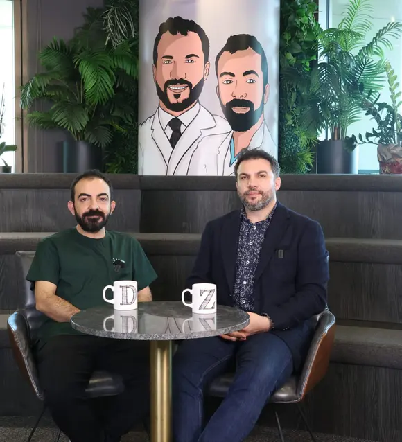 Two doctors of the Exotic Touch team seated at a table in the clinic lounge