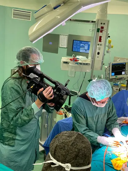 A camera operator filming beside the surgeon during an operation