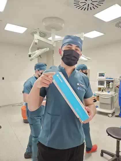 A member of the surgical team holding an implant box in theatre
