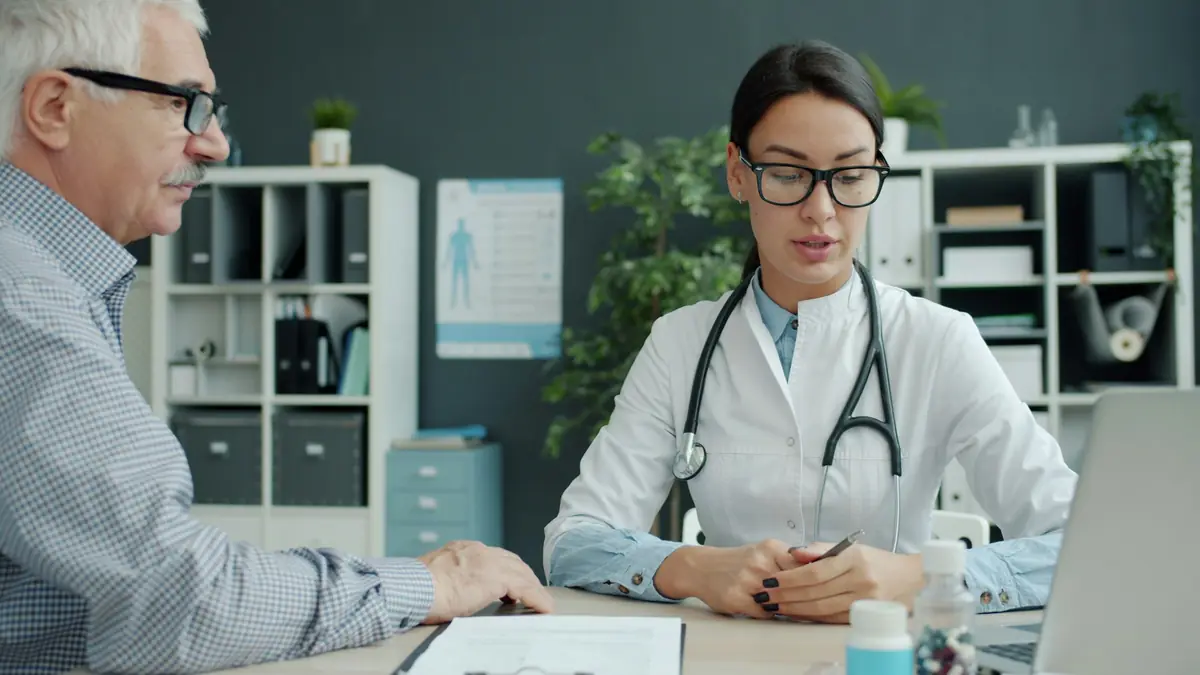 A doctor talking with an older male patient during a consultation