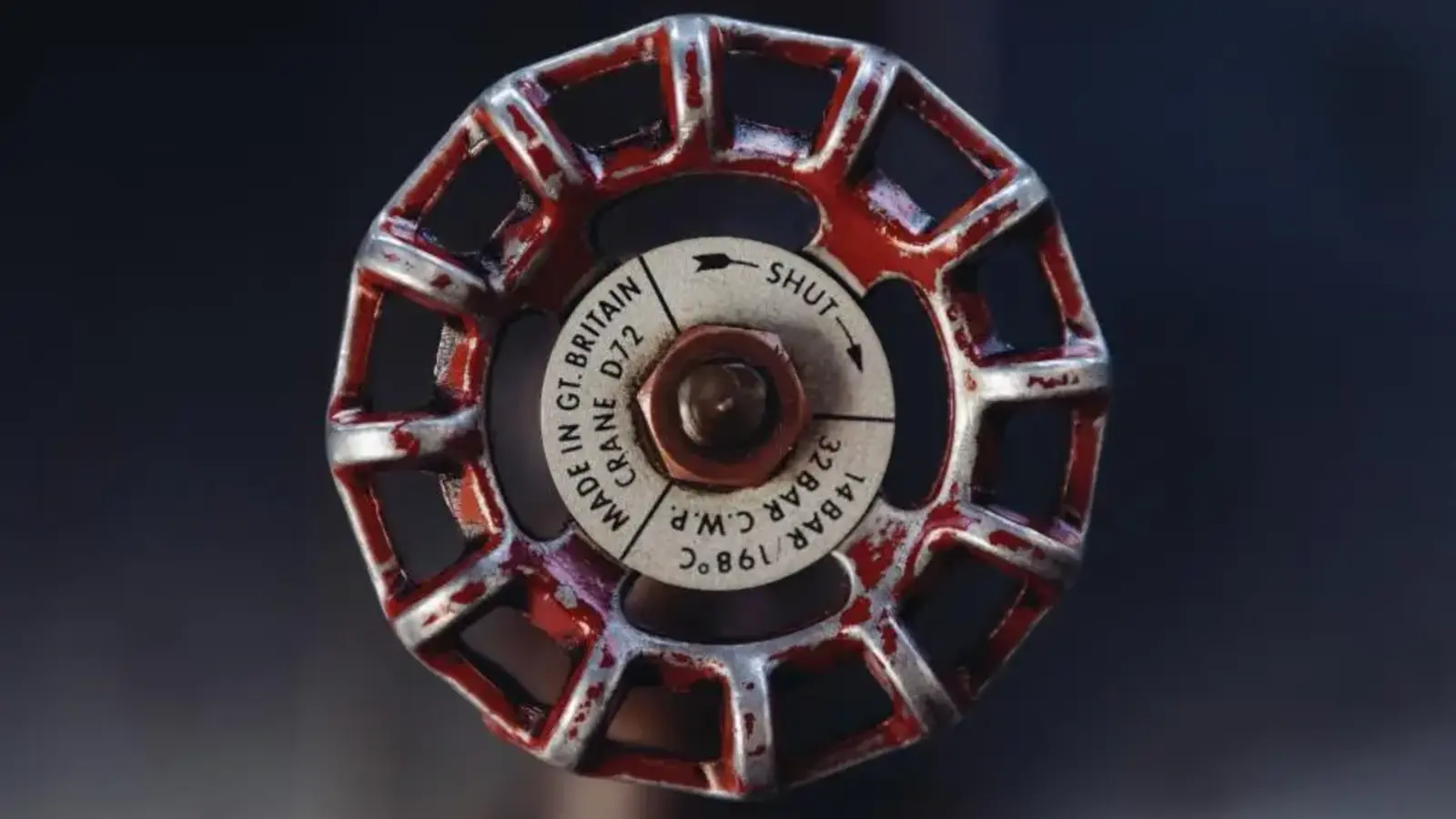 Close-up of a red valve wheel on a pipe