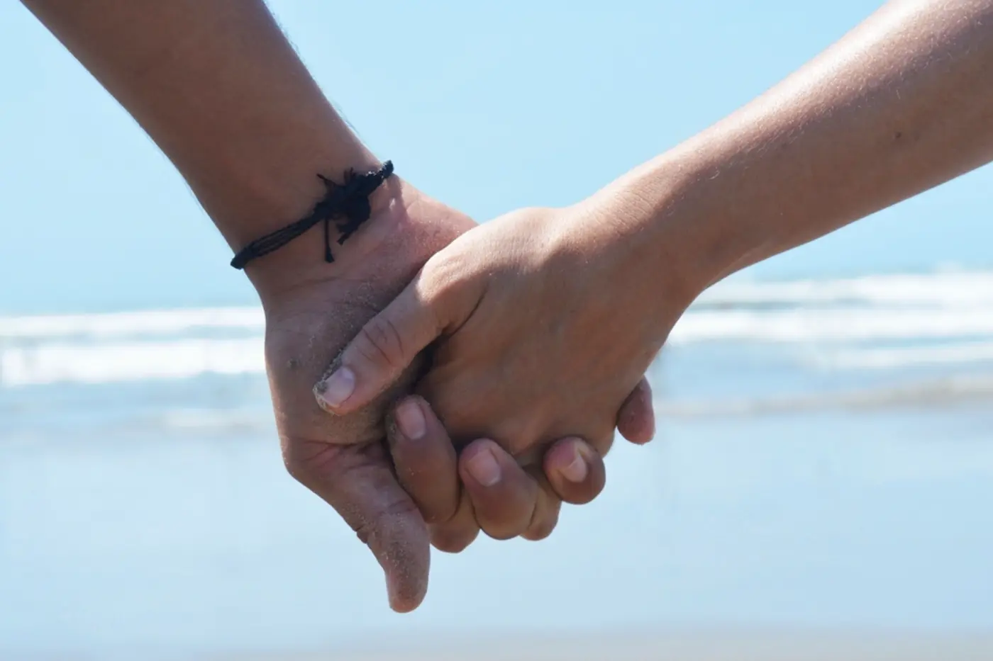 Couple holding hands by the sea