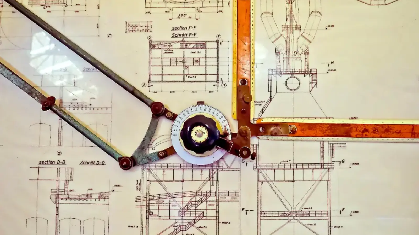 A technical drawing with drafting tools on top