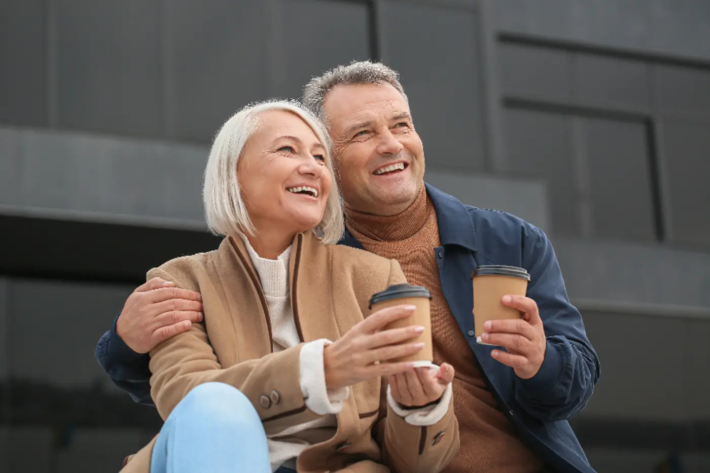 An older couple laughing together on a sofa