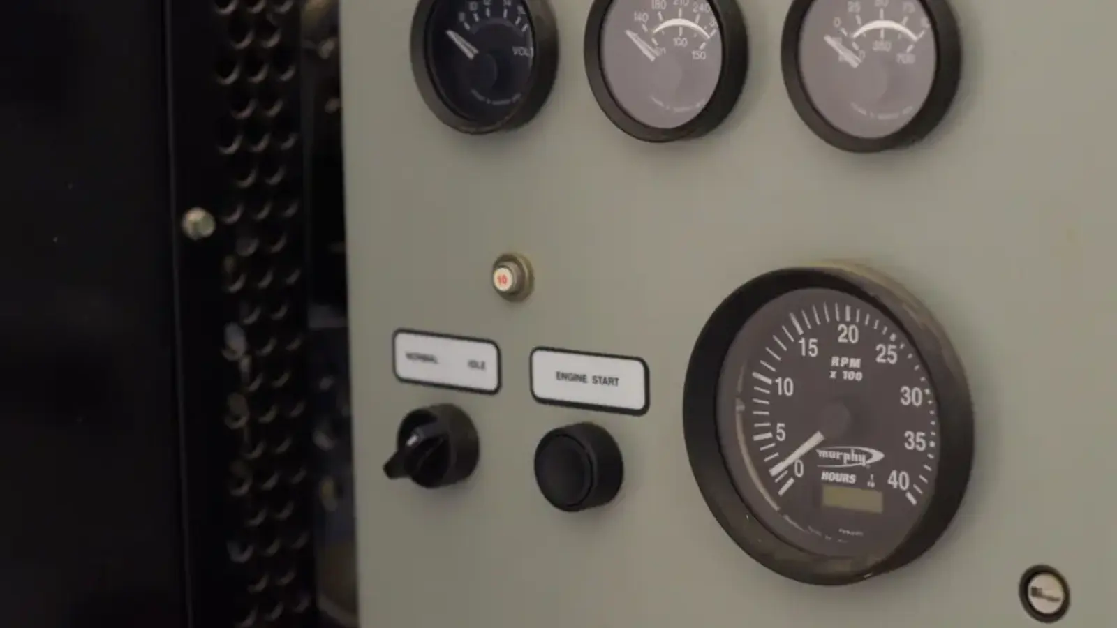 A metal control panel with round pressure gauges
