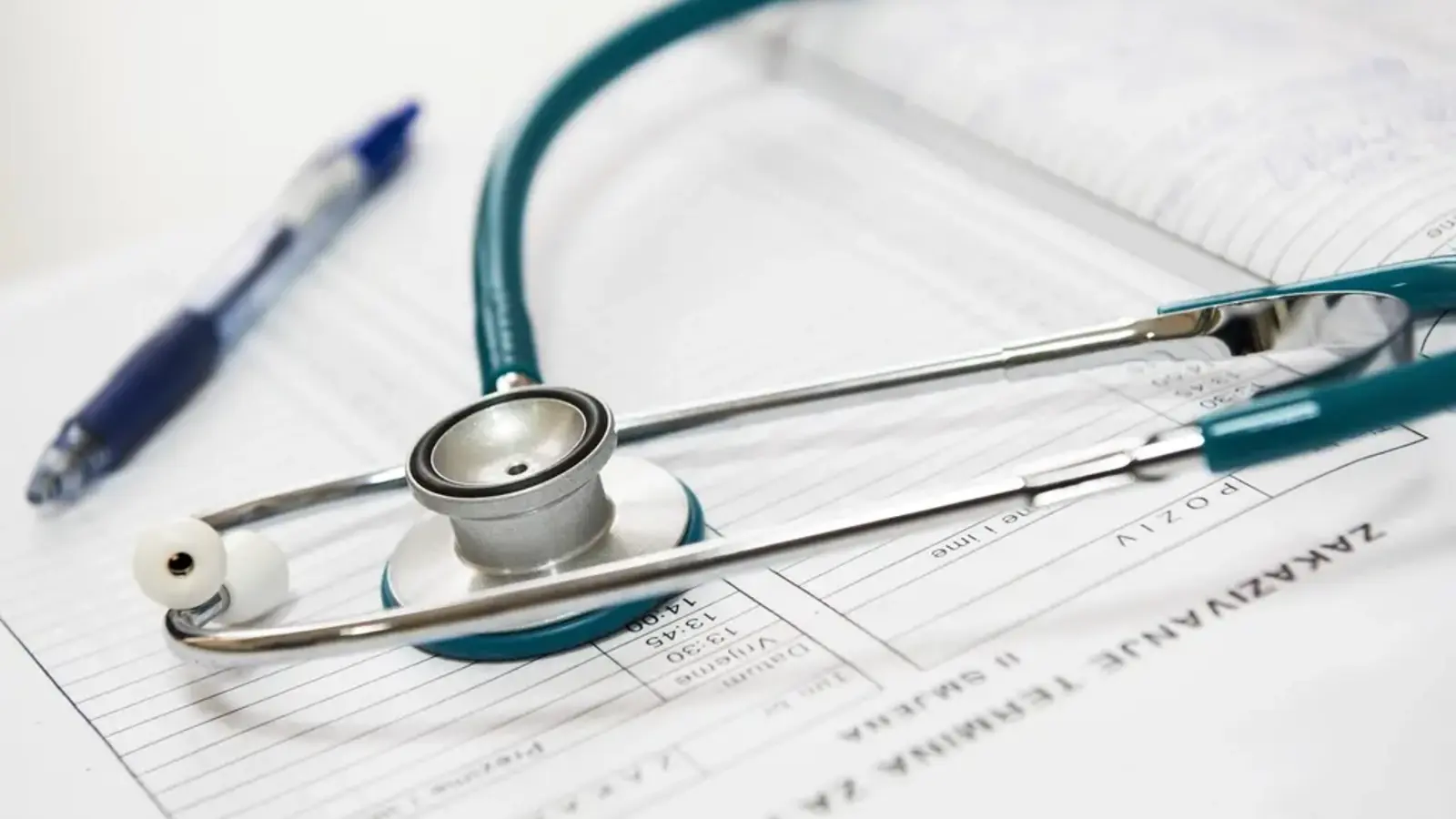 A stethoscope and pen lying on a paper form