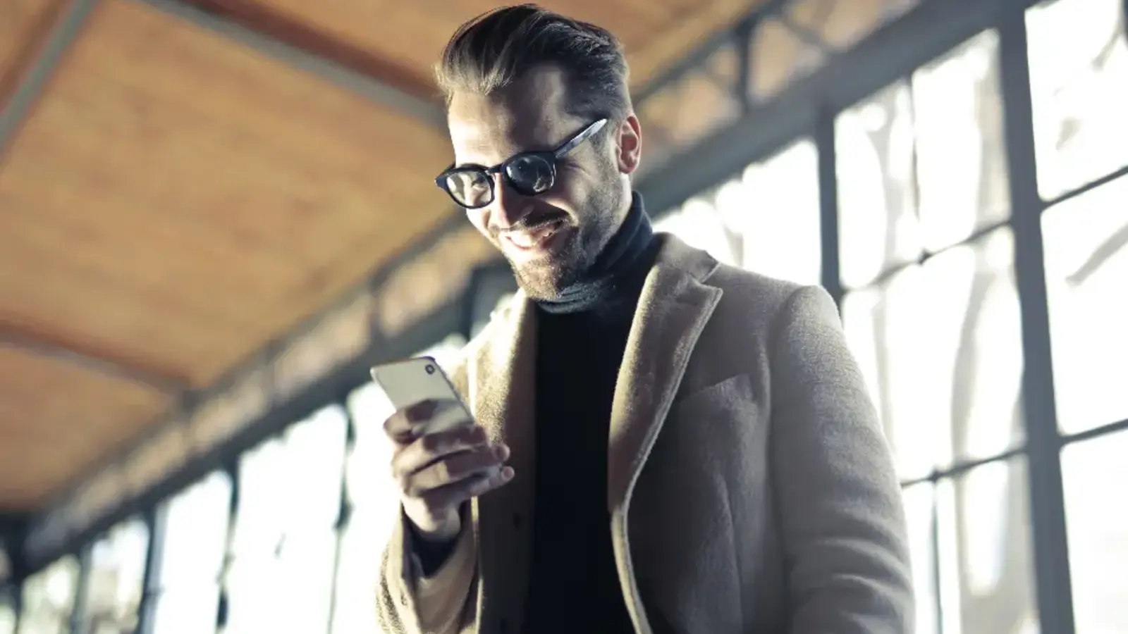 A man with glasses looking at his phone