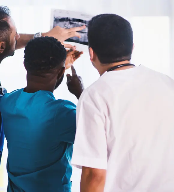 Three clinicians reviewing an X-ray image together