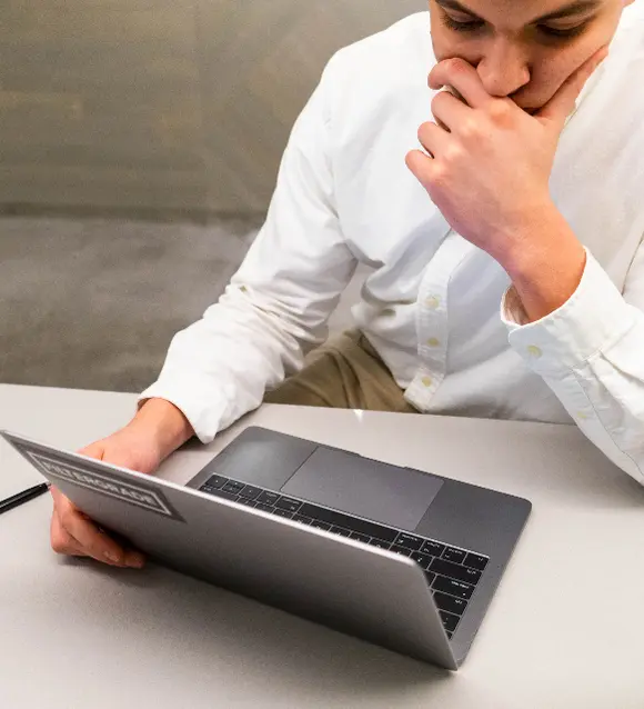 Man thinking in front of a laptop