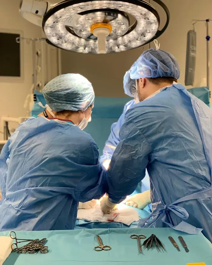Surgeons performing a penile implant operation under sterile conditions